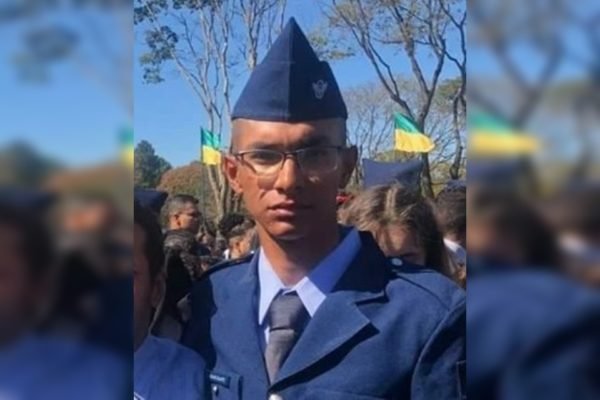 Soldado com terno e chapeu azul. Ele usa óculos e está com a cara fechada
