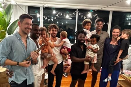 Foto colorida de atores da Globo segurando seus filhos no colo - Metrópoles