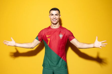 Cristiano Ronaldo em fundo amarelo com o uniforme de Portugal - Metrópoles