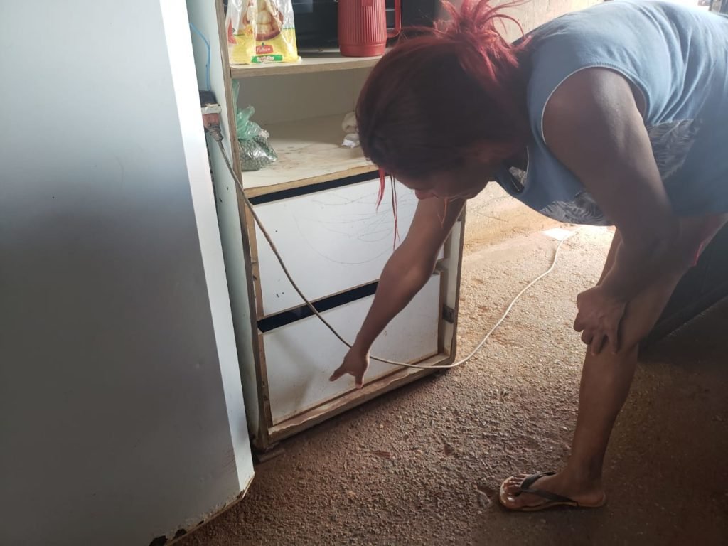 Estrago em casas no Sol Nascente, na Ceilândia, após fortes chuvas. Na foto vê-se mulher mostra estrago em móveis dentro de casa - Metrópoles