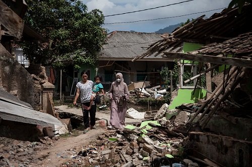 pessoas caminham sobre casas desabadas em terremoto na indonésia - metrópoles