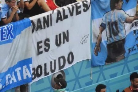 Imagem colorida mostra torcedores argentinos levam faixa xingando Daniel Alves com frase usada por Maradona - Metrópoles