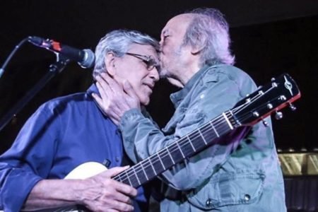 Erasmo Carlos beija a testa de Caetano Veloso em cima de palco - metrópoles