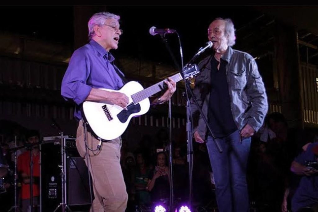 Caetano Veloso e Erasmo Carlos cantando em palco - metrópoles