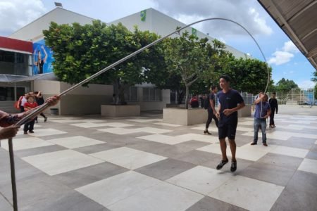 Foto colorida do pátio de uma escola com alunos pulando corda - Metrópoles