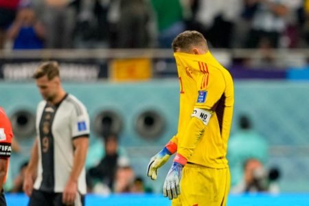 Goleiro Neuer da Alemanha cobre o rosto com a camisa amarela após derrota contra o Japão na Copa do Mundo do Catar de 2022 - Metrópoles