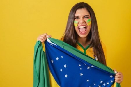 mulher segurando a bandeira do Brasil - Metropóles