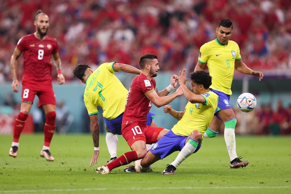Dusan Tadic da Sérvia colide com Lucas Paqueta e Marquinhos do Brasil durante a partida do Grupo G da Copa do Mundo da FIFA Qatar 2022 entre Brasil e Sérvia no Lusail Stadium em 24 de novembro de 2022 na cidade de Lusail, Qatar