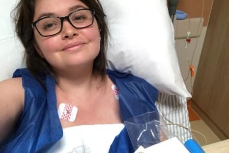 imagem de mulher jovem com lúpus deitada em cama de hospital após pulsoterapia