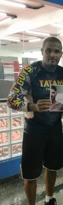Líder de religião de matriz africana acusado de estupro. Homem de regata preta mostra foto de um lutador de jiu-jitsu - Metrópoles