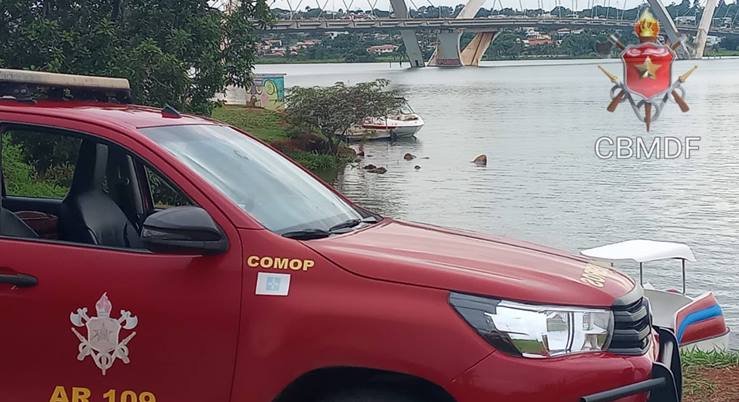 imagem colorida de carro do Corpo de Bombeiros às margens do Lago Paranoá e com a Ponte JK ao fundo - Metrópoles