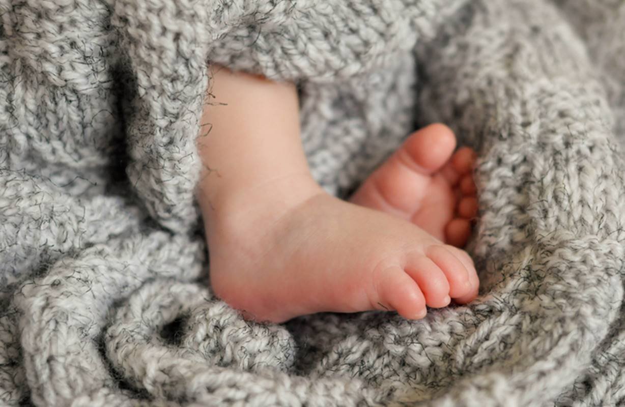 Imagem colorida: pés de bebê envolvidos em cobertor - Metrópoles