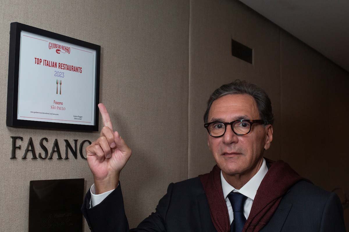 restaurateur Gero Fasano aponta para quadro com premiação do Gambero Rosso