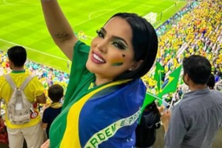 Foto colorida da influenciadora Juliana Priscila com bandeira do Brasil - Metrópoles
