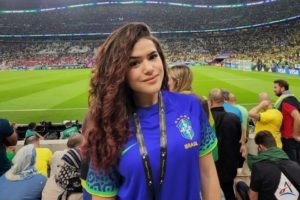 Maisa, vestida com uma camisa azul da seleção brasileira, posa no estádio Lusail - Metrópoles