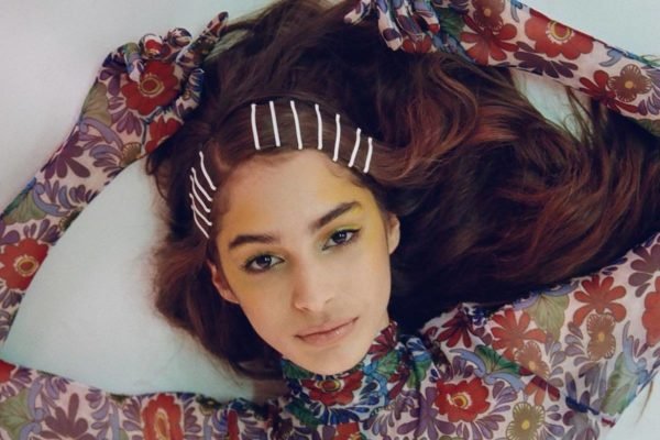Na imagem, jovem deitada, de cabelo castanho liso, com grampos - Metrópoles