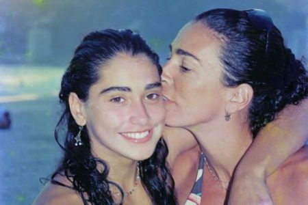 Carol Solberg, na adolescência, recebe um beijo da mãe, Isabel Salgado - Metrópoles