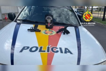 Viatura da polícia militar do Distrito Federal com duas armas no capô aprendidas com homens que atiraram-as após jogo do Brasil - Metrópoles