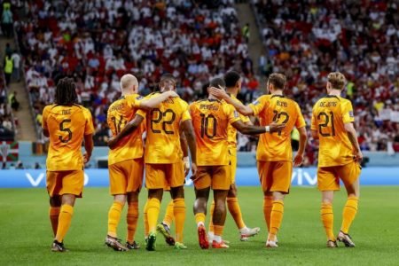 Seleção da Holanda comemora gols contra Catar em campo na Copa do Mundo do Catar. Eles usam uniforme laranja - Metrópoles