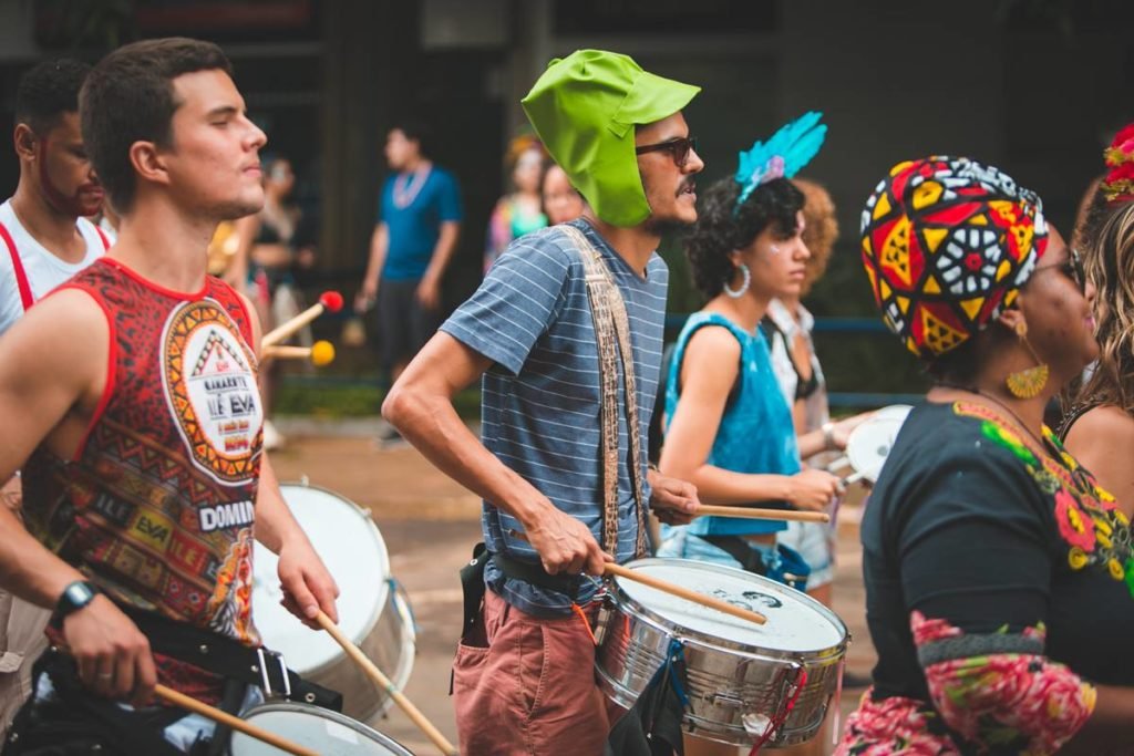 pessoas fantasiadas tocando tambores - metrópoles