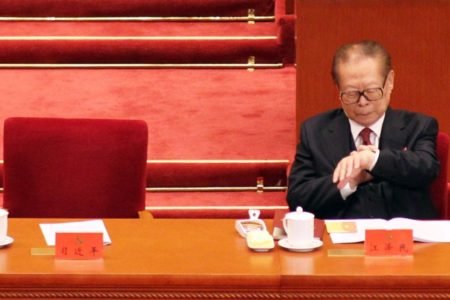 Imagem colorida mostra um homem oriental de terno olhando o relógio. É Jiang Zemin, ex-presidente da China - Metrópoles