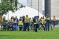 Grupo de pessoas trajadas com roupas nas cores da bandeira do Brasil e camisetas amarelas, em gramado em frente ao Congresso Nacional, em Brasília - Metrópoles