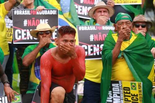 Manifestantes bolsonaristas participam de protesto golpista em frente ao QG do Exército, em Brasília, pedindo intervenção militar. Eles seguram cartazes afirmando que o
