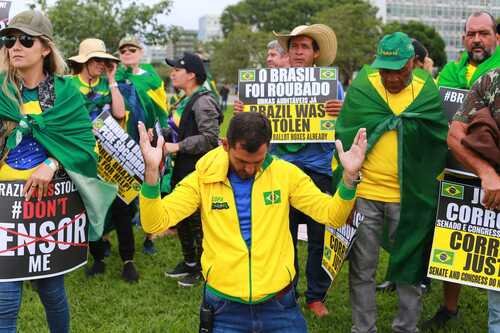 Manifestantes bolsonaristas participam de protesto golpista em frente ao QG do Exército, em Brasília, pedindo intervenção militar. Eles seguram cartazes afirmando que o