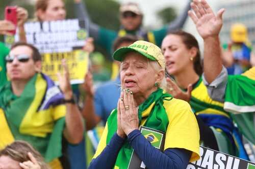 Manifestantes bolsonaristas participam de protesto golpista em frente ao QG do Exército, em Brasília, pedindo intervenção militar. Eles seguram cartazes afirmando que o
