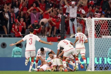 Jogadores da Tunísia comemoram vitória sob a França em estádio da Copa do Mundo do Catar, correndo para se abraçar - Metrópoles