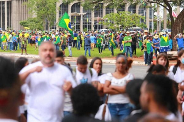 Bolsonaristas, ao fundo, impedem manifestantes que usam roupas brancas de protestarem a favor da ampliação do rol da ANS próximos ao Palácio da Justiça - Metrópoles