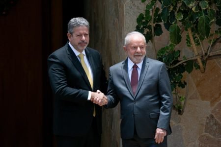 O presidente eleito Lula se encontra com Arthur Lira, presidente da Câmara dos Deputados, em sua residência oficial. Na foto, ambos apertam as mãos e sorriem para as fotos - Metrópoles
