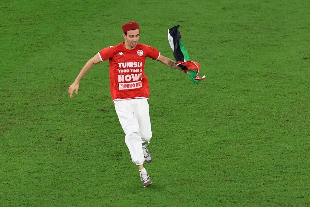 Torcedor invade campo de jogo entre Tunísia e França com uma bandeira da Palestina e seguranças o retiram carregado - Metrópoles
