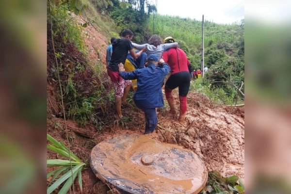 Imagem colorida mostra pessoas em cima da lama onde mãe e filha estavam soterradas e foram resgatadas com vida em Santa Catarina - Metrópoles