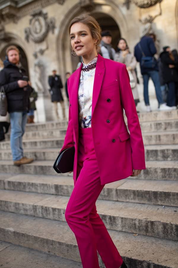 Em imagem de street style, a modelo Natalia Vodianova usa blazer e calça de alfaiataria na cor magenta - Metrópoles