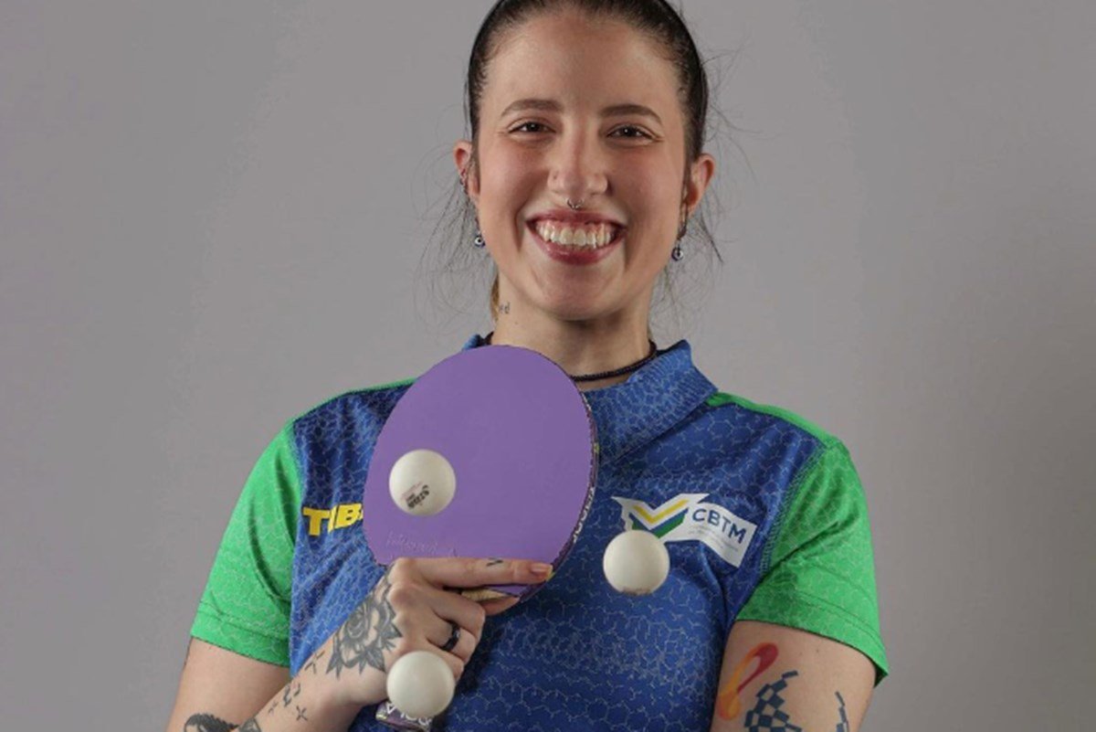 Foto colorida mostra a atleta paralímpica Jennyfer Parinos com uma raquete de tênis de mesa e três bolinhas