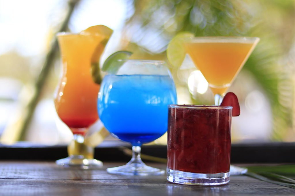 Na imagem, vários drinques coloridos em taças diferentes - Metrópoles