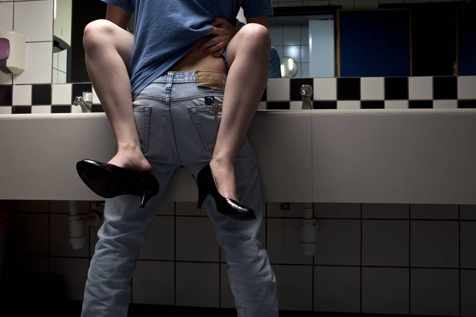 Foto em close das pernas de um casal fazendo sexo em cima da bancada da pia de um banheiro - Metrópoles