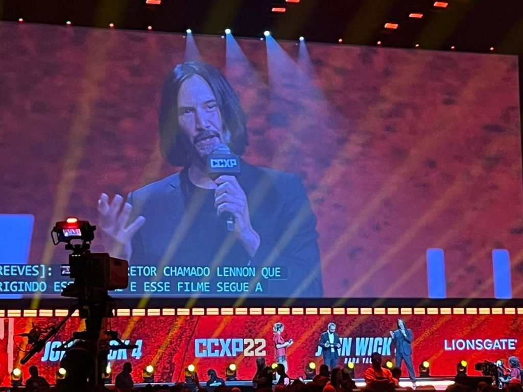 Keanu Reaves falando em cima do palco CCXP