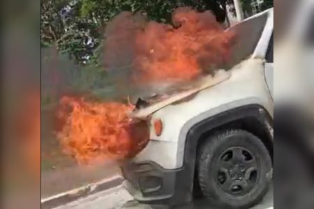 Imagem colorida de carro branco em chamas