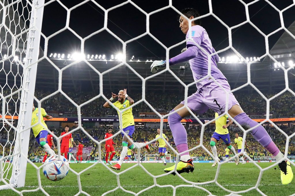 Nesta foto tirada de uma câmera remota atrás do gol) Neymar do Brasil comemora após marcar o segundo gol do time enquanto Seunggyu Kim da Coreia do Sul reage durante a Copa do Mundo da FIFA Qatar 2022 Round of 16 entre Brasil e Coreia do Sul no Estádio 974 em 05 de dezembro de 2022 em Doha, Qatar