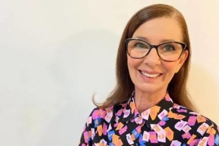 Márcia Manfredine de óculos e camisa colorida - Metrópoles