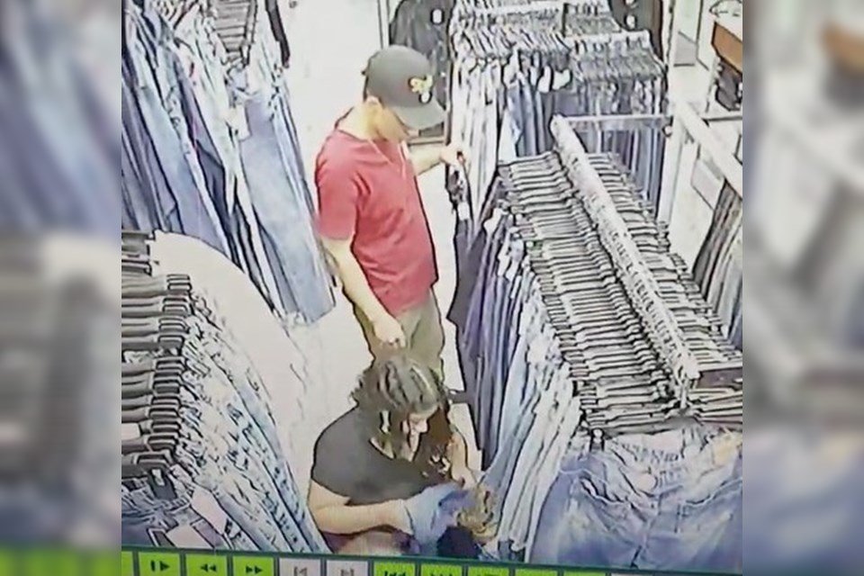 Homem e mulher entre roupas jeans em loja