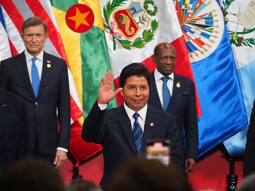 Presidente do Peru, Pedro Castillo, durante cerimônia. Ele cumprimenta os jornalistas e plateia erguendo a mão e sorrindo - Metrópoles