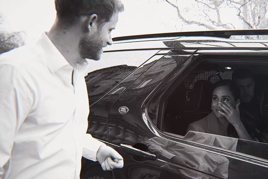 Black and white photograph of a white man outside a car and a woman crying inside the vehicle - Metropoles