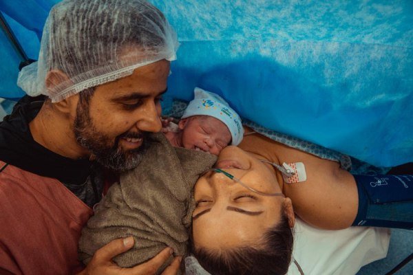Poliana na mesa de operação com a filha, no dia do nascimento da bebê