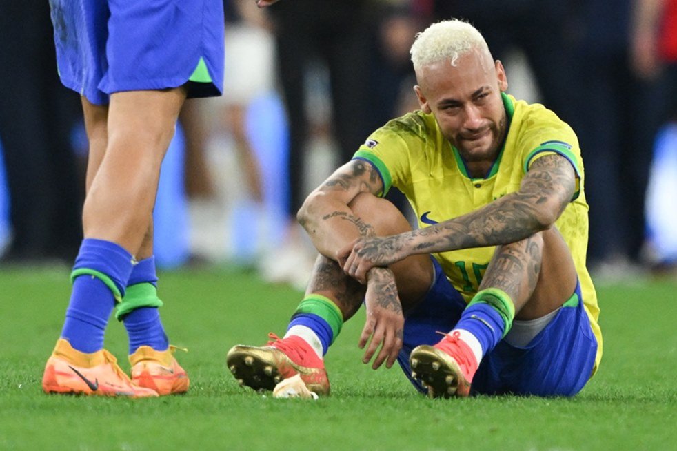 Jogadores De Futebol Sentados Lado a Lado Num Campo De Futebol