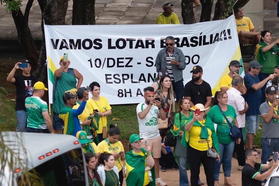 Imagem mostra manifestantes reunidos em frente ao Supremo Tribunal Militar.  Eles usam roupas com bandeiras do Brasil - Metrópoles
