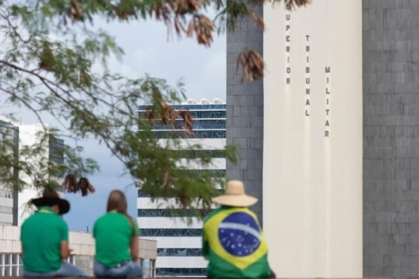 Imagem mostra manifestantes reunidos em frente ao Supremo Tribunal Militar. Eles usam roupas com bandeiras do Brasil - Metrópoles