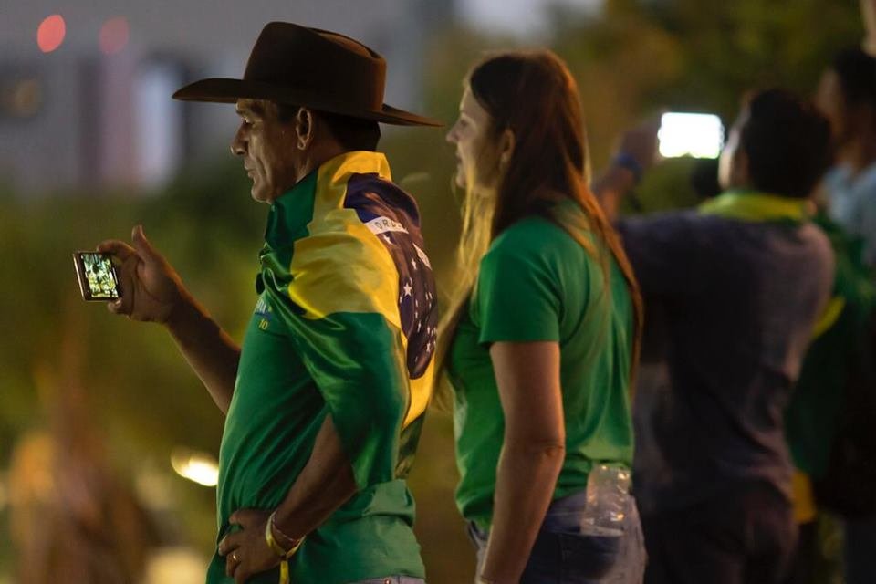 Imagem mostra manifestantes reunidos em frente ao Supremo Tribunal Militar.  Eles usam roupas com bandeiras do Brasil - Metrópoles